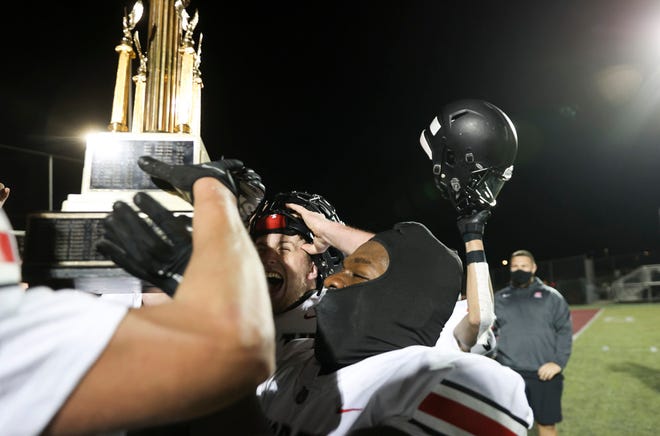 North Salem's Josiah Davis (5), who scored five touchdowns, hoist the Mayor's Trophy after their 41-30 victory at South High School on March 26, 2021.