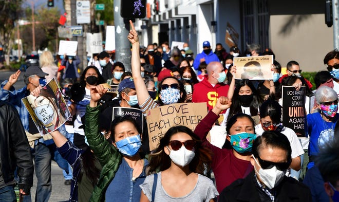 Social activists hold signs as they march from San Gabriel City Hall to Alhambra City Hall in California on March 26, 2021, during an anti-Asian hate rally. The protesters were joined by leaders from the respective cities in the San Gabriel Valley, home to one of the largest Asian American communities in the United States. (Photo by Frederic J. BROWN/AFP via Getty Images)