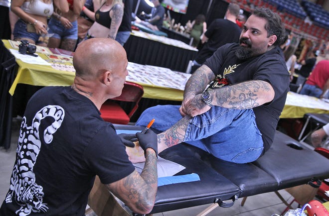 West Texas Tattoo Convention organizer Alex Trufant, right, gets some work done by Ami James, left, during the event at the Foster Coliseum on Saturday, March 27, 2021.