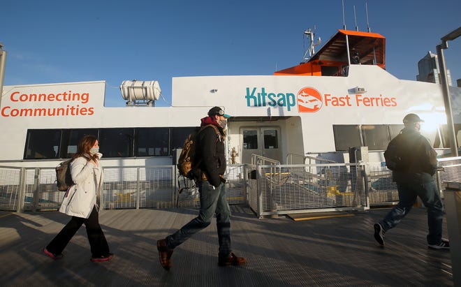 Passengers walk along the dock after disembarking the M/V Enetai in Seattle on Monday, March 29, 2021. 