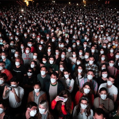 People using face masks attend a music concert in 