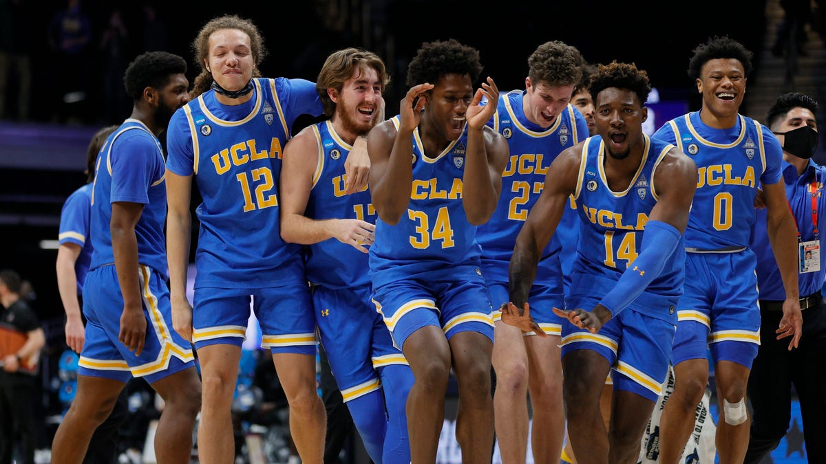 David Singleton of the UCLA Bruins and Kenneth Nwuba celebrate with teammates after defeating the Alabama Crimson Tide 88-78 in overtime in the Sweet Sixteen round game of the 2021 NCAA Men's Basketball Tournament at Hinkle Fieldhouse.