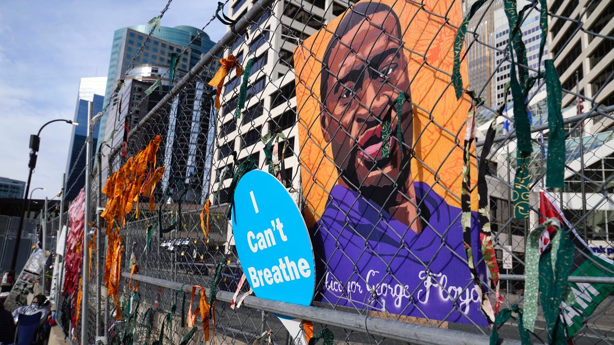 A picture of George Floyd hangs on a fence outside the Hennepin County Government Center, Tuesday, March 30, 2021, in Minneapolis where the trial for former Minneapolis police officer Derek Chauvin continues. Chauvin is charged with murder in the death of Floyd during an arrest last May in Minneapolis.