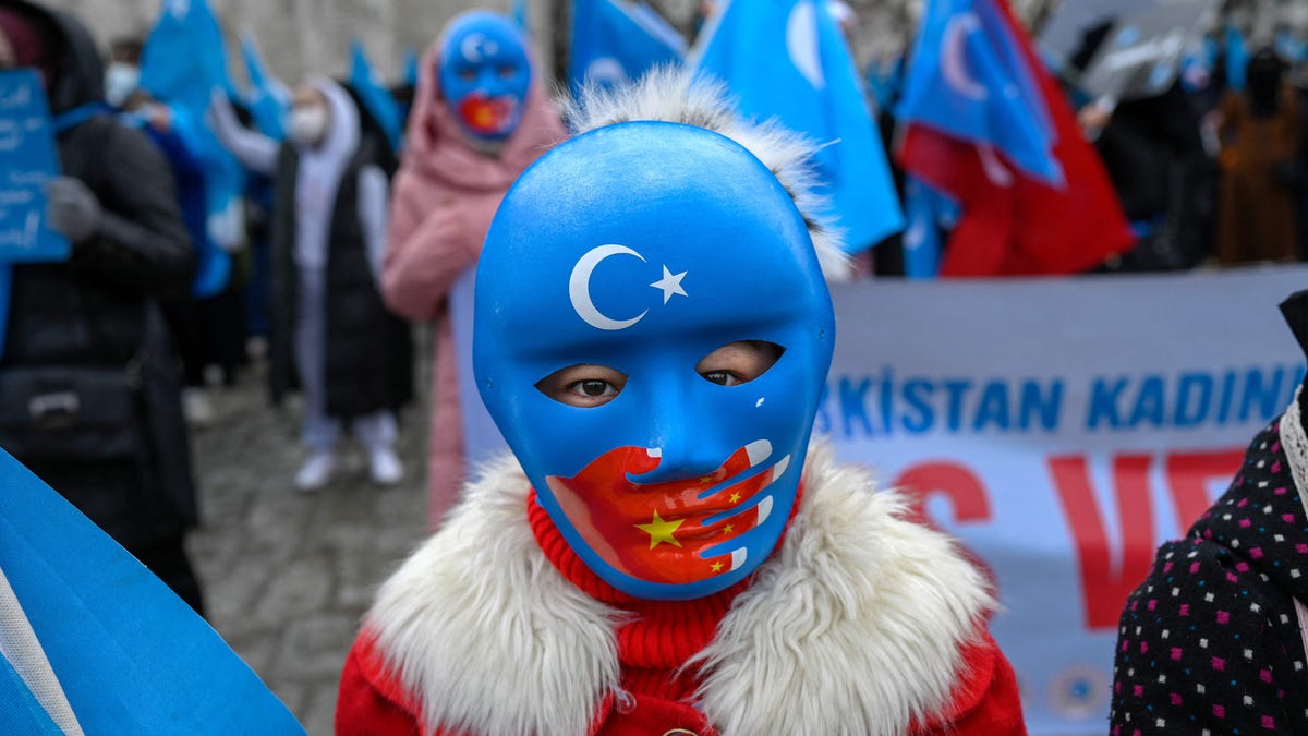 A child from the Uyghur community living in Turkey wears a mask during a protest against the visit of China's foreign minister to Turkey, in Istanbul on March 25, 2021.