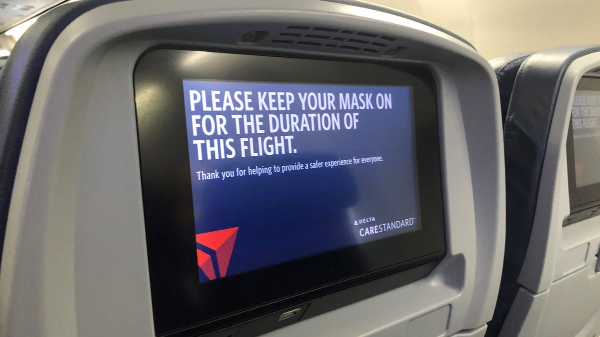 Seatback video screens on Delta Air Lines planes remind travelers that masks are required throughout the flight.