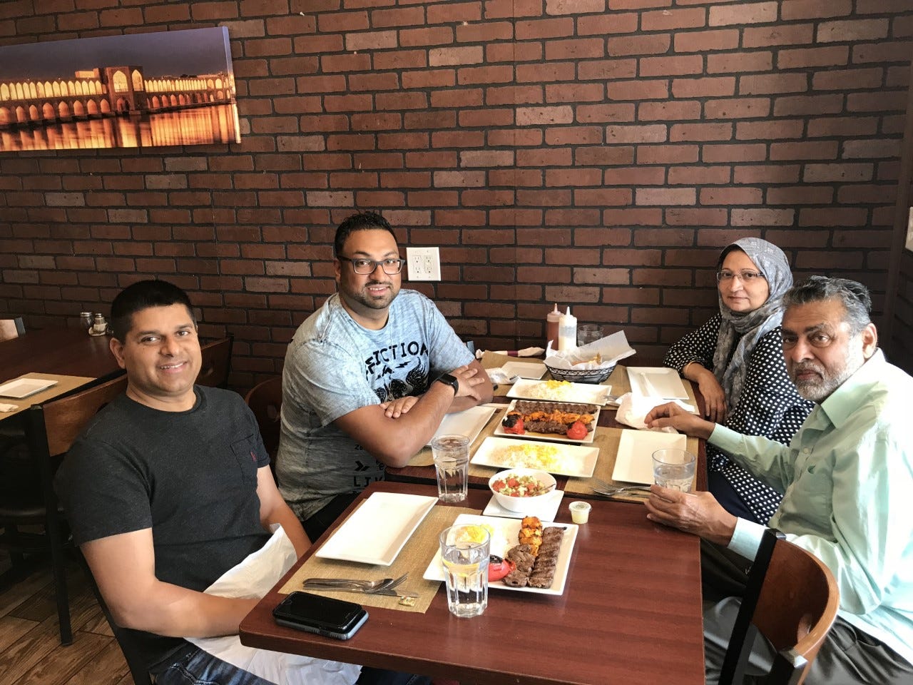 Sameer Sarmast sits with his cousin Sameer Ahmed and his parents, Amina and Syed Sarmast, at their favorite restaurant Kabob on the Cliff in Rutherford, New Jersey.