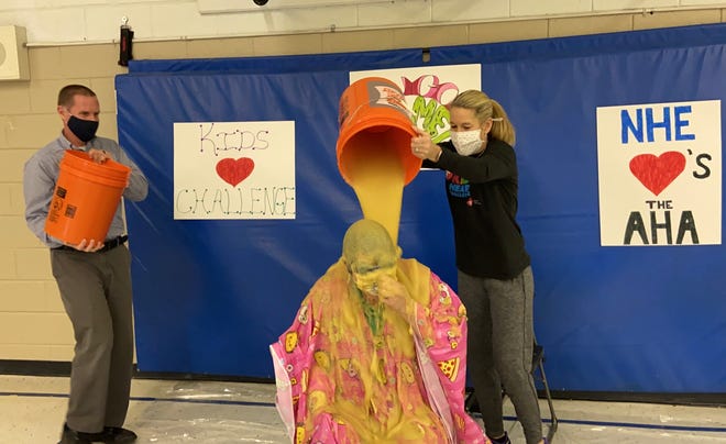 New Hope Elementary PE teacher Shelly Burke pours a bucket of "slime" onto New Hope Principal Lynn Whiteside on Thursday, April 1, 2021. Sliming Whiteside was a reward for New Hope students after they raised more than $12,000 for the American Heart Association.