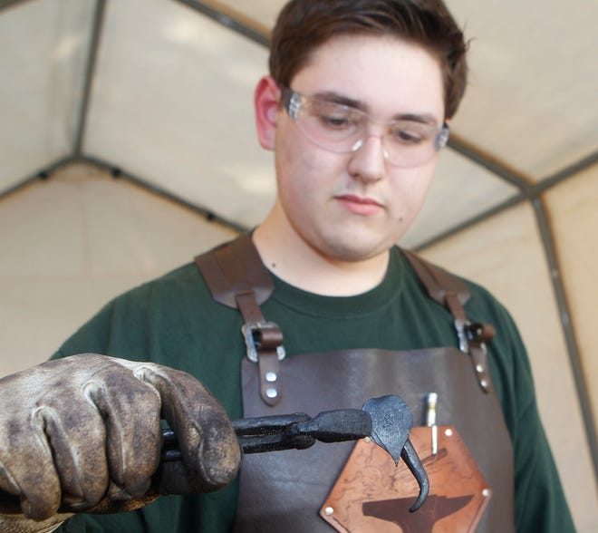 Nicholas Riolo, 17, of Bellingham, inspects his work as he works in his own blacksmith shop out in the backyard of his family's house.