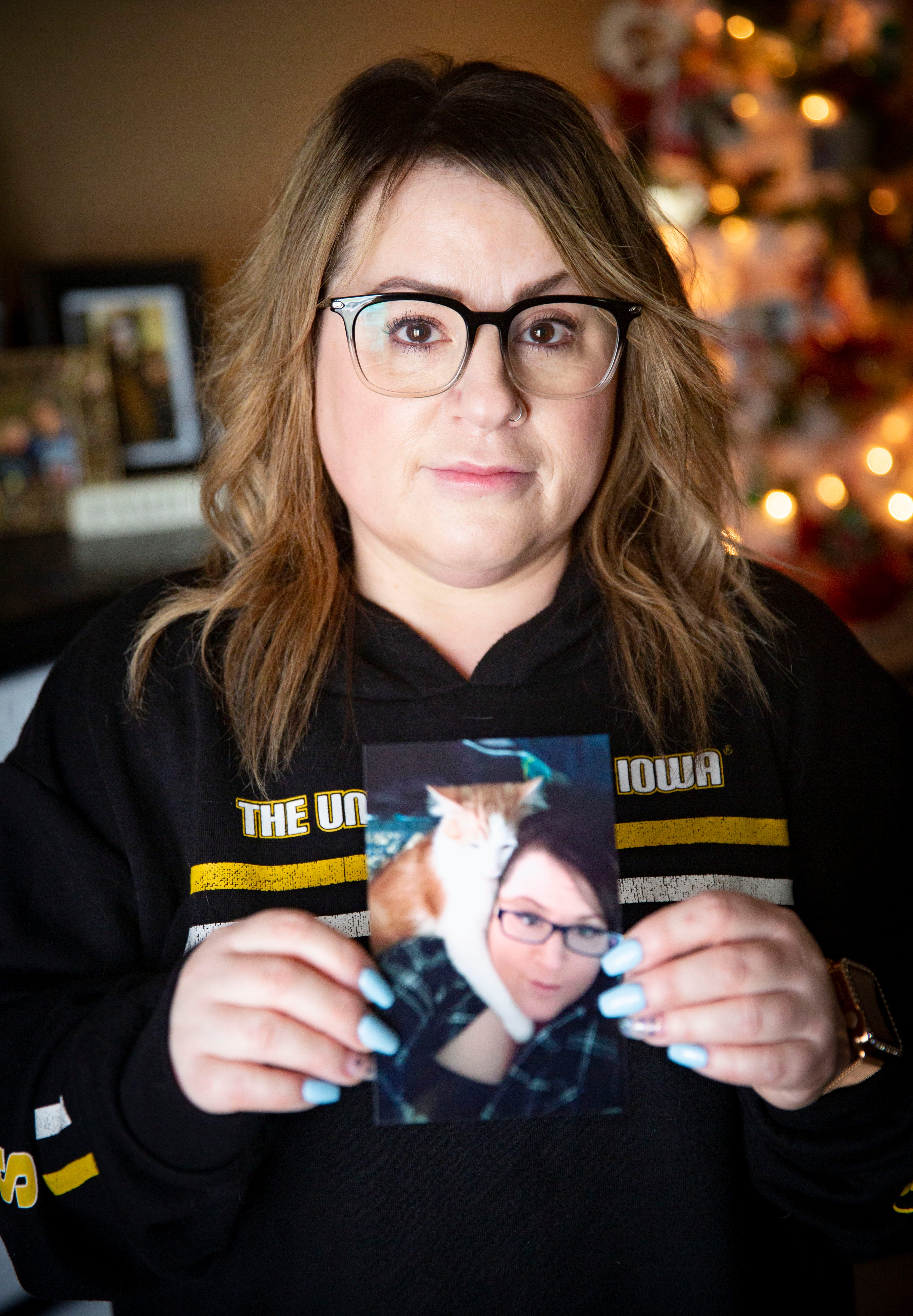 Cynthia Recanati holds a photo of her identical twin sister Michele Recanati at her home in Oelwien Wednesday, March 31, 2021. Michele died of Coronavirus in December of 2020. 