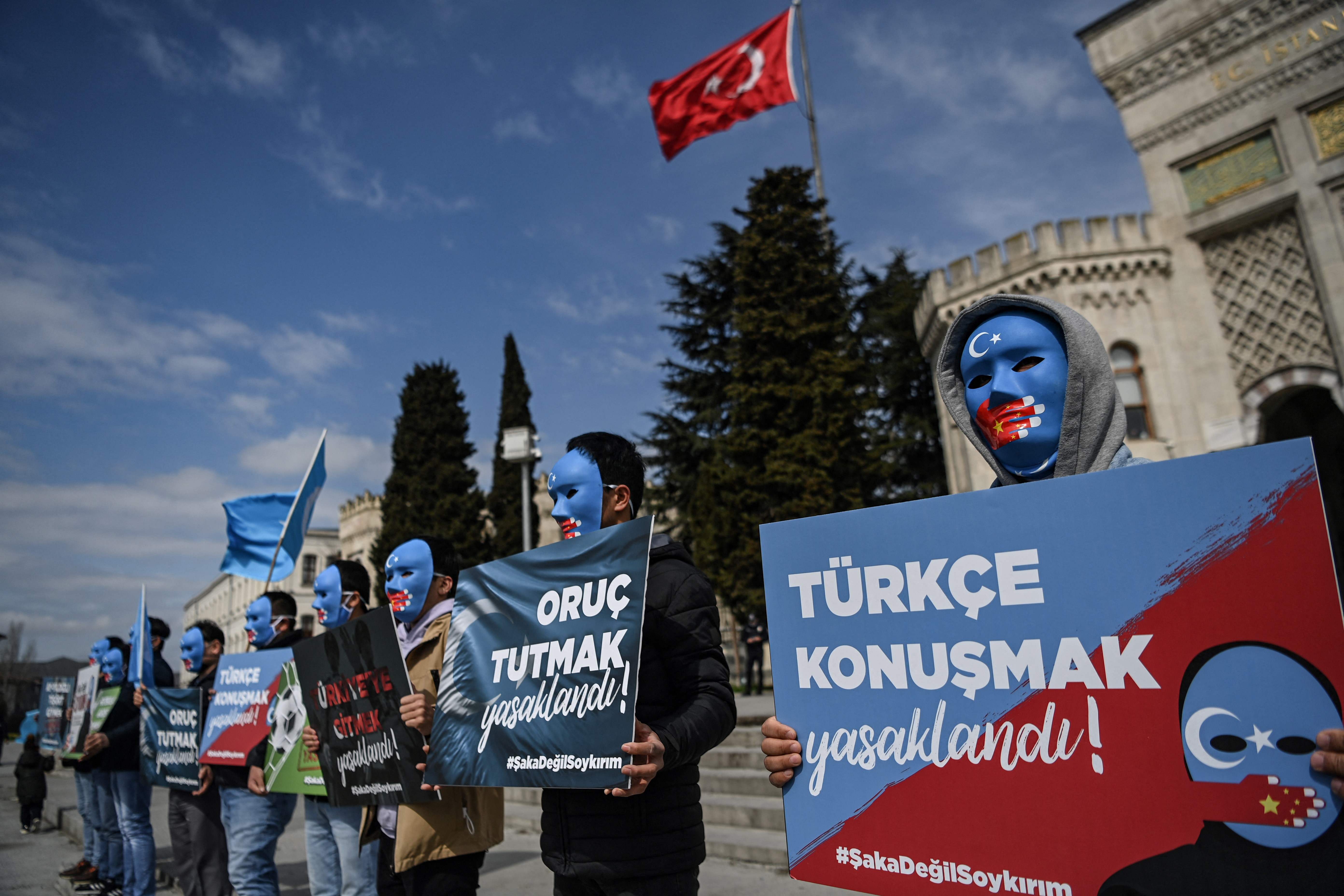 Demonstrators wearing a mask painted with the colors of the flag of East Turkestan hold placards reading "Speaking Turkish , banned" and "fasting in Ramadan, banned" during a protest by supporters of the Uyghur minority on Thursday at Beyazid Square in Istanbul, Turkey. At least one million Uyghurs and people from other mostly Muslim groups have been held in camps in northwestern Xinjiang, China, according to rights groups, who accuse Chinese authorities of forcibly sterilizing women and imposing forced labor.