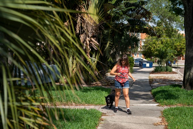 Angela walks Silky down the street they live on in Tampa on Tuesday, March 30, 2021. 
