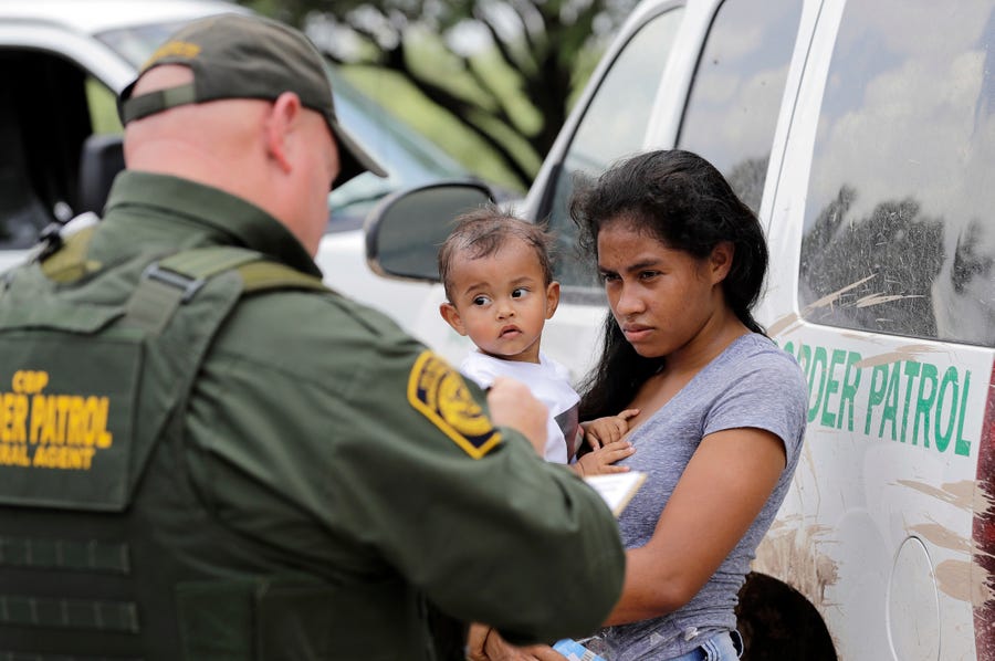 A mother from Honduras with her 1-year-old child surrenders to U.S. Border Patrol agents June 25, 2018, after illegally crossing the border near McAllen, Texas.