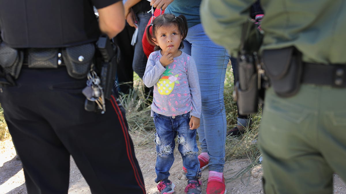 A Mission Police Dept. officer (L), and a U.S. Border Patrol agent watch over a group of Central American asylum seekers before taking them into custody on June 12, 2018 near McAllen, Texas. Local police officers often coordinate with Border Patrol agents in the apprehension of undocumented immigrants near the border. The immigrant families were then sent to a U.S. Customs and Border Protection (CBP) processing center for possible separation. U.S. border   authorities are executing the Trump administration's "zero tolerance" policy towards undocumented immigrants. U.S. Attorney General Jeff Sessions also said that domestic and gang violence in immigrants' country of origin would no longer qualify them for political asylum status.  (Photo by John Moore/Getty Images)