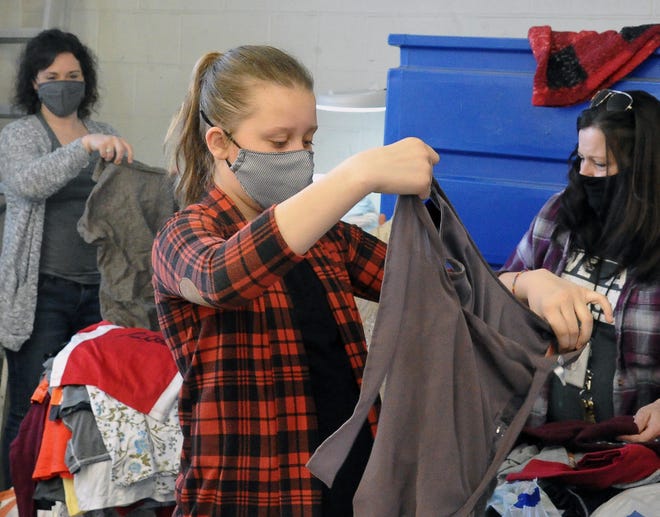 Anderson "Andi" Musser, a fifth-grader at Shreve Elementary, sorts through gently used clothing at Goodwill in Wooster. She'll use the donated items to stock the Kindness Closet at school.