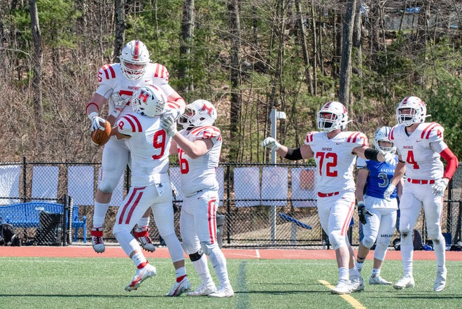 Holliston High senior Zack Athy (top left) celebrates with teammates after scoring his first high school touchdown in the Panthers' win over Ashland on Friday at Ashland High School.