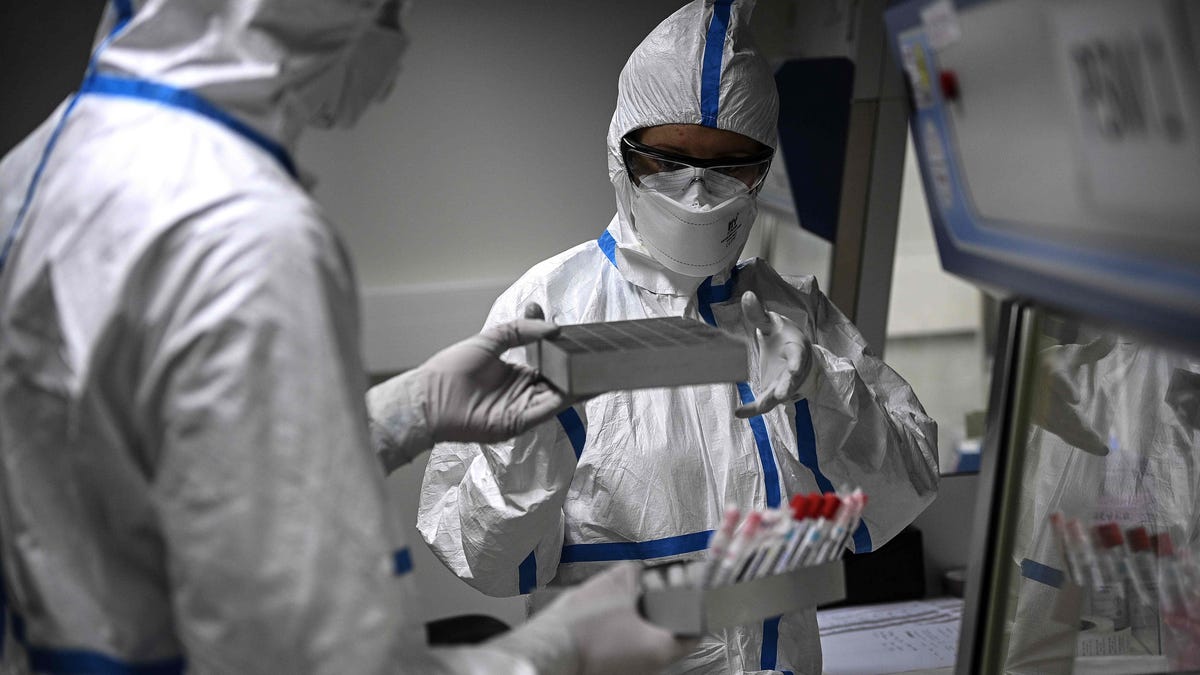 Laboratory technicians wearing protective equipment work on the genome sequencing of the SARS-CoV-2 virus, which causes COVID-19, and its variants at the National Reference Center (CNR) for Respiratory Infection Viruses at the Pasteur Institute in Paris on Thursday, Jan. 21, 2021.