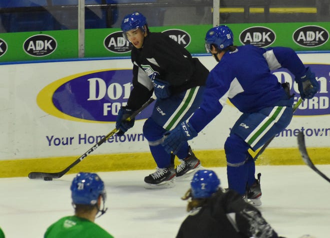 Mitch Reinke, left, looks for an open teammate during a Utica Comets practice earlier this season. Reinke and the Comets have returned to practice this week after halting activities since March 11 following issues with the coronavirus.