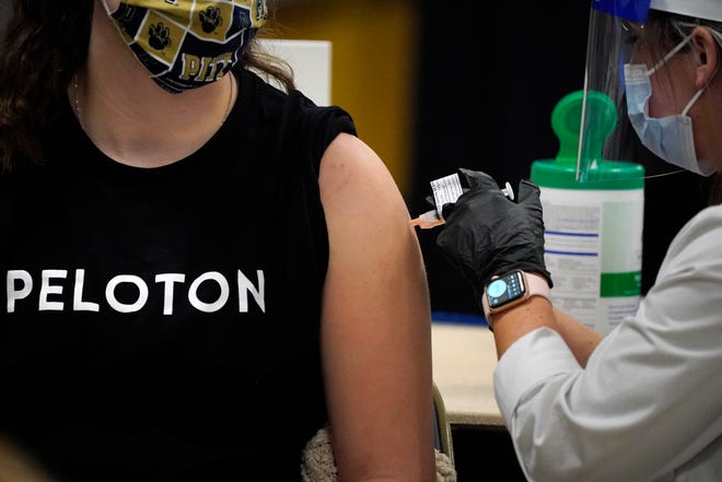 A student receives her first dose of the Moderna COVID-19 vaccine during a vaccination clinic hosted by the University of Pittsburgh.