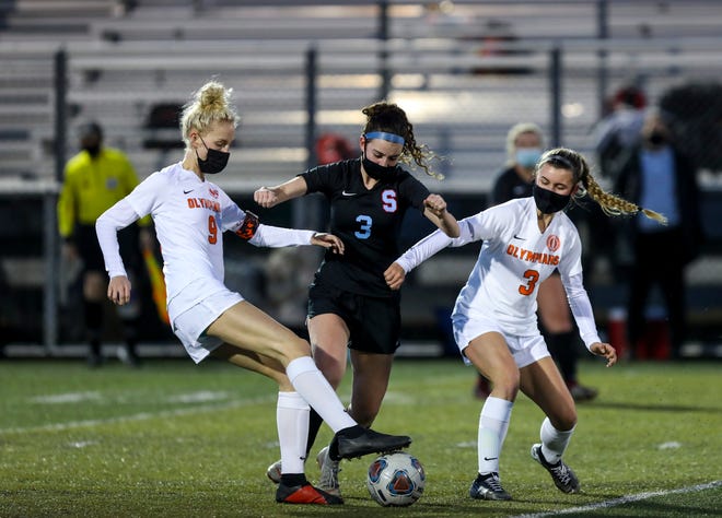 South Salem's Emily Hargis (3) kicks the ball while Sprague's Aspen DeConcini (9) and McKenzie Wernicke (3) attempt to steal it on April 5, 2021, in Salem, Oregon.