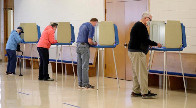 Edwin Nonhof, far right, leaves the voting booth after deciding his choices at the First Congregational Church poll April 6, 2021, in Sheboygan.
