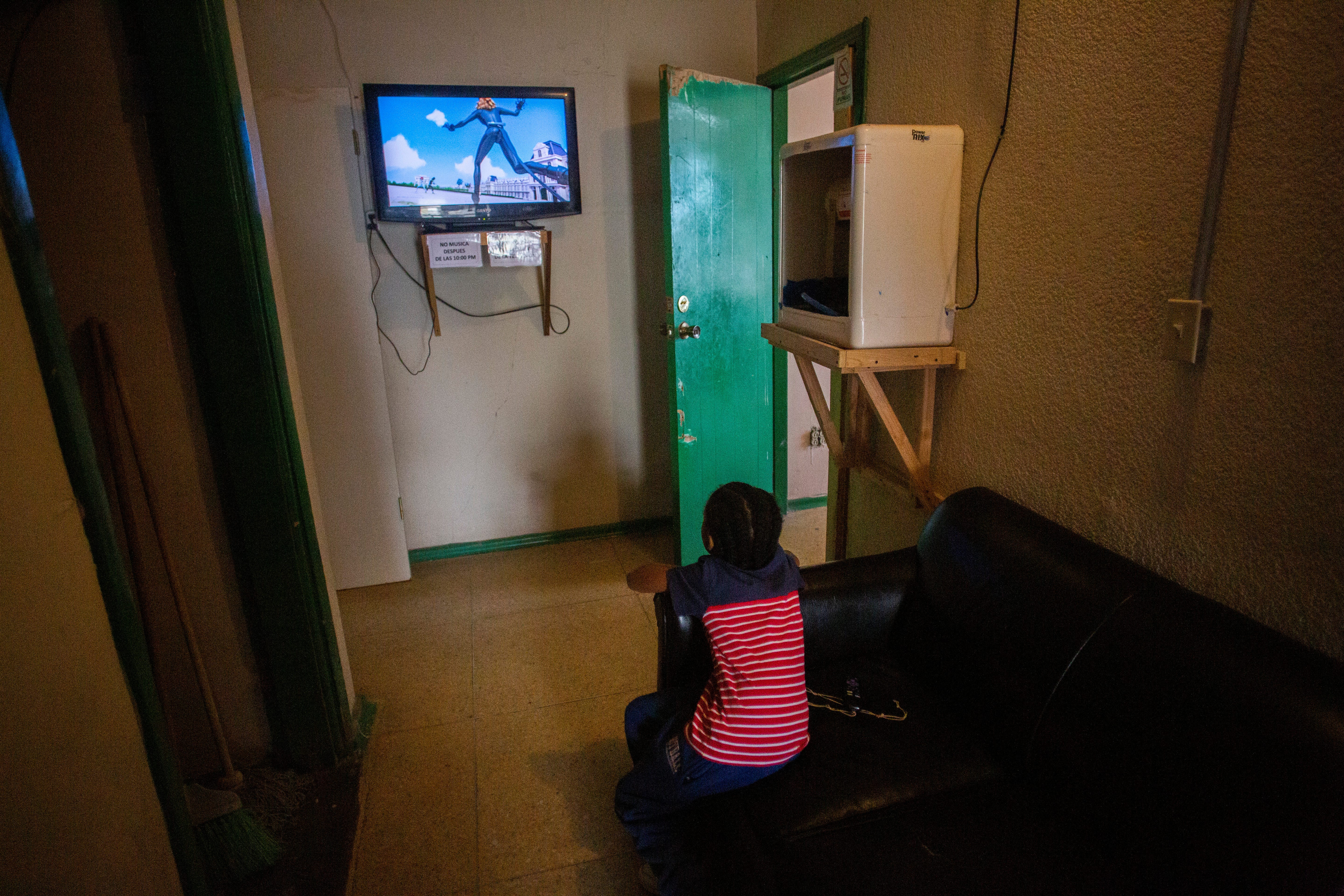 A Haitian child who recently arrived from Tijuana watches cartoons. The child and his parents attempted to enter the U.S. that night but were returned and decided to return to Tijuana, Baja California.