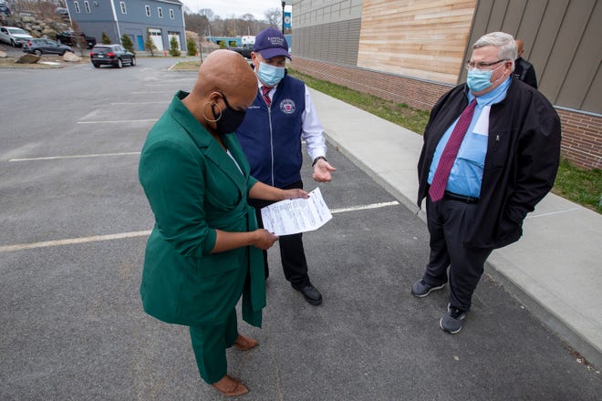 Randolph is a key toward an initiative in organizing free vaccination clinics for Haitian residents across the Commonwealth on Dec. 18. Here,  Congresswoman Ayanna Pressley looks at a vaccine ticket with Randolph Public Health Director Gerard Cody, middle, and Randolph Town Manager Brian Howard, right, on a tour of Randolph's vaccination site in April.