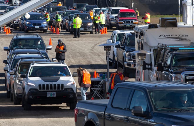Cars full of people wanting a COVID-19 vaccine lineup in the parking lot of Autzen Stadium in late March.