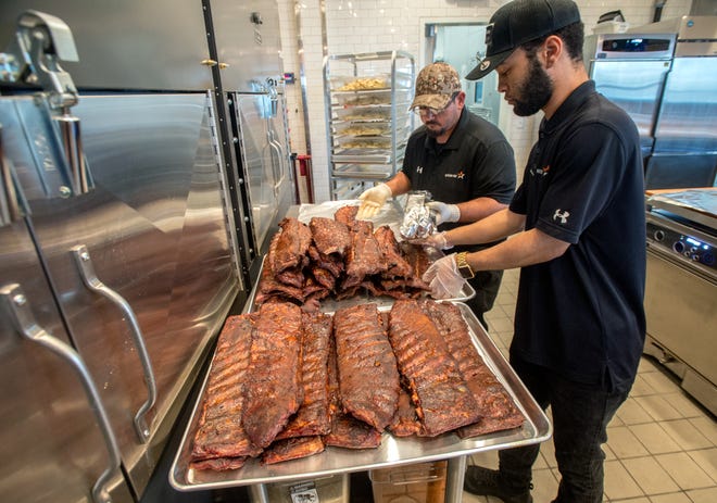 Jamari Mullen, right, and Pablo Hernandez wrap up a healthy heaping of barbecue ribs as they prepare for a private party Wednesday, April 7, 2021 at Mission BBQ, 4513 N. Sterling Ave. in Peoria. The pair are part of a training team teaching staff members at the new restaurant before its official opening on April 12.