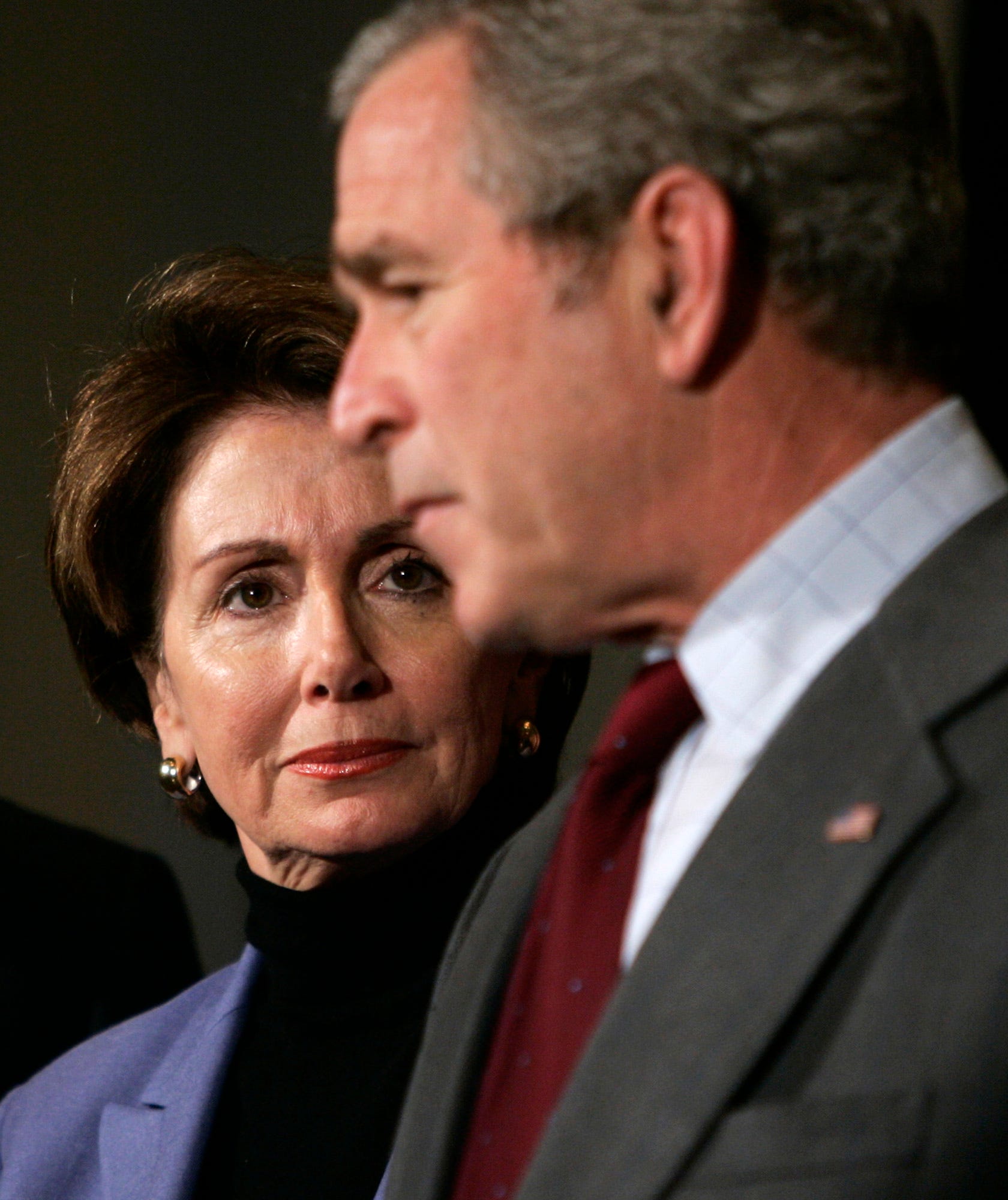 Speaker of the House Rep. Nancy Pelosi, D-Calif., left, looks on as President Bush speaks at the House Democratic Issues Conference on Feb. 3, 2007, in Williamsburg, Va.