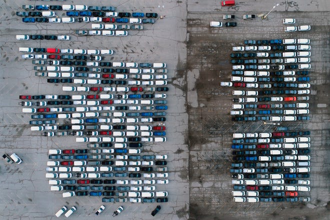 In this aerial photo, mid-sized pickup trucks and full-size vans are seen in a parking lot outside a General Motors assembly plant where they are produced Wednesday, March 24, 2021, in Wentzville, Mo.   The global shortage of semiconductors is forcing General Motors to further cut production at six North American factories as chip supplies seem to be growing tighter. The shutdowns likely will crimp dealer inventory of vehicles made at the plants, but GM says it has managed to keep factories humming that make hot-selling and profitable full-size pickup trucks and SUVs.  (AP Photo/Jeff Roberson)