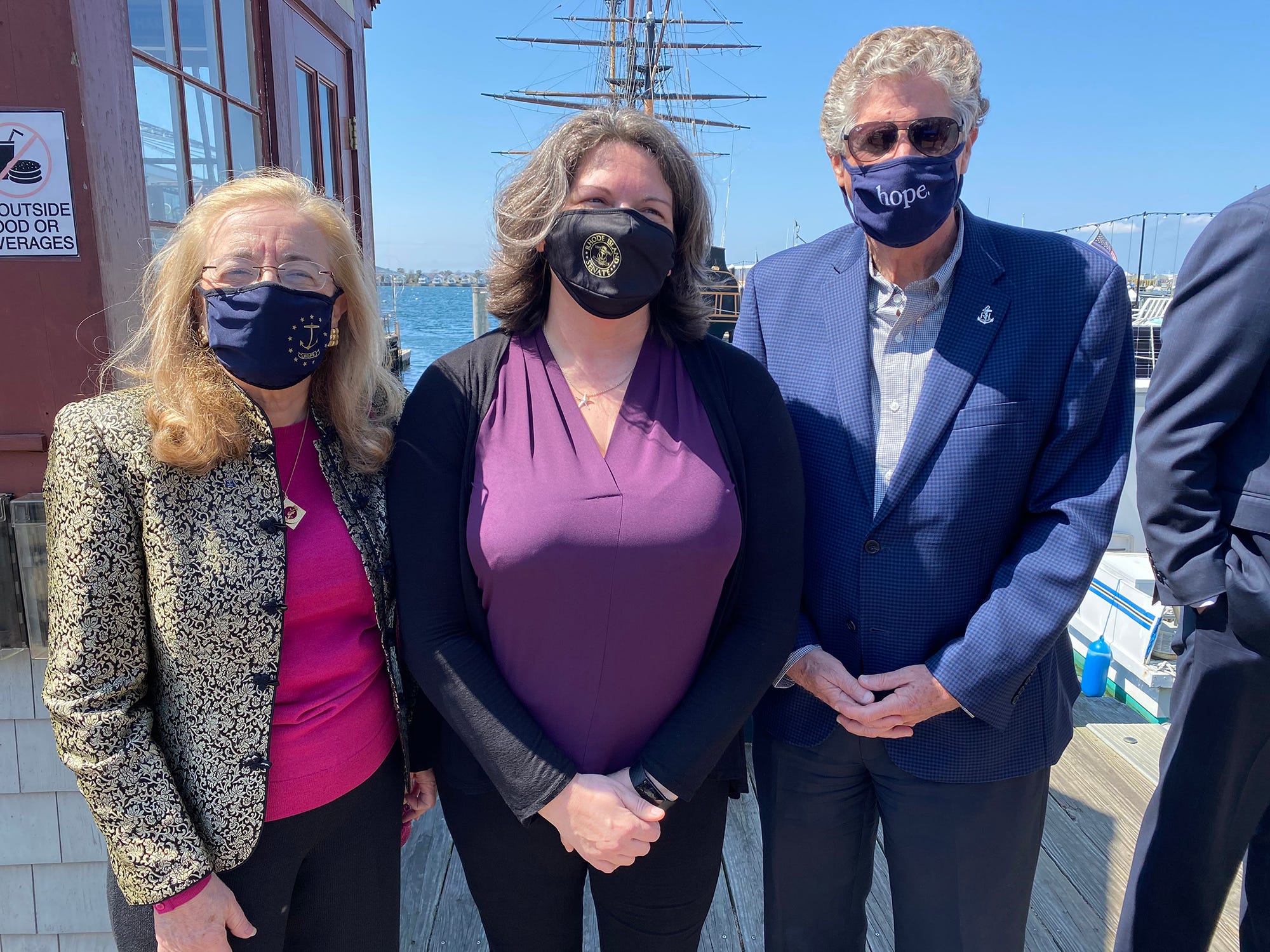 Gov. Dan McKee stands with Rep. Lauren Carson, left, and Sen. Dawn Euer, the Newport Democrats who introduced the Act on Climate bill, during a ceremony Saturday on Bowen's Wharf.