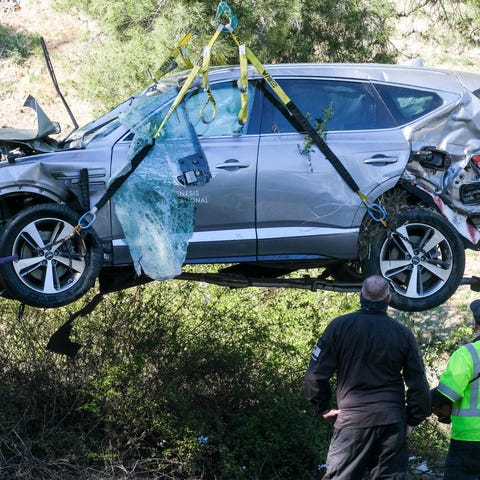 A crane is used to lift Tiger Woods' vehicle follo