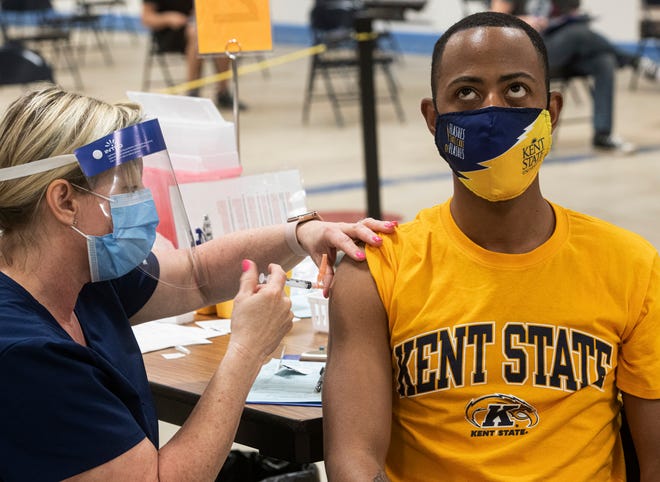 Kent State University student Marz Anderson gets his Johnson & Johnson COVID-19 vaccination from Kent State nurse Beth Krul in Kent, Ohio, Thursday, April 8, 2021. U.S. colleges hoping for a return to normalcy next fall are weighing how far they should go in urging students to get the COVID-19 vaccine, including whether they should â€” or legally can â€” require it. (AP Photo/Phil Long)