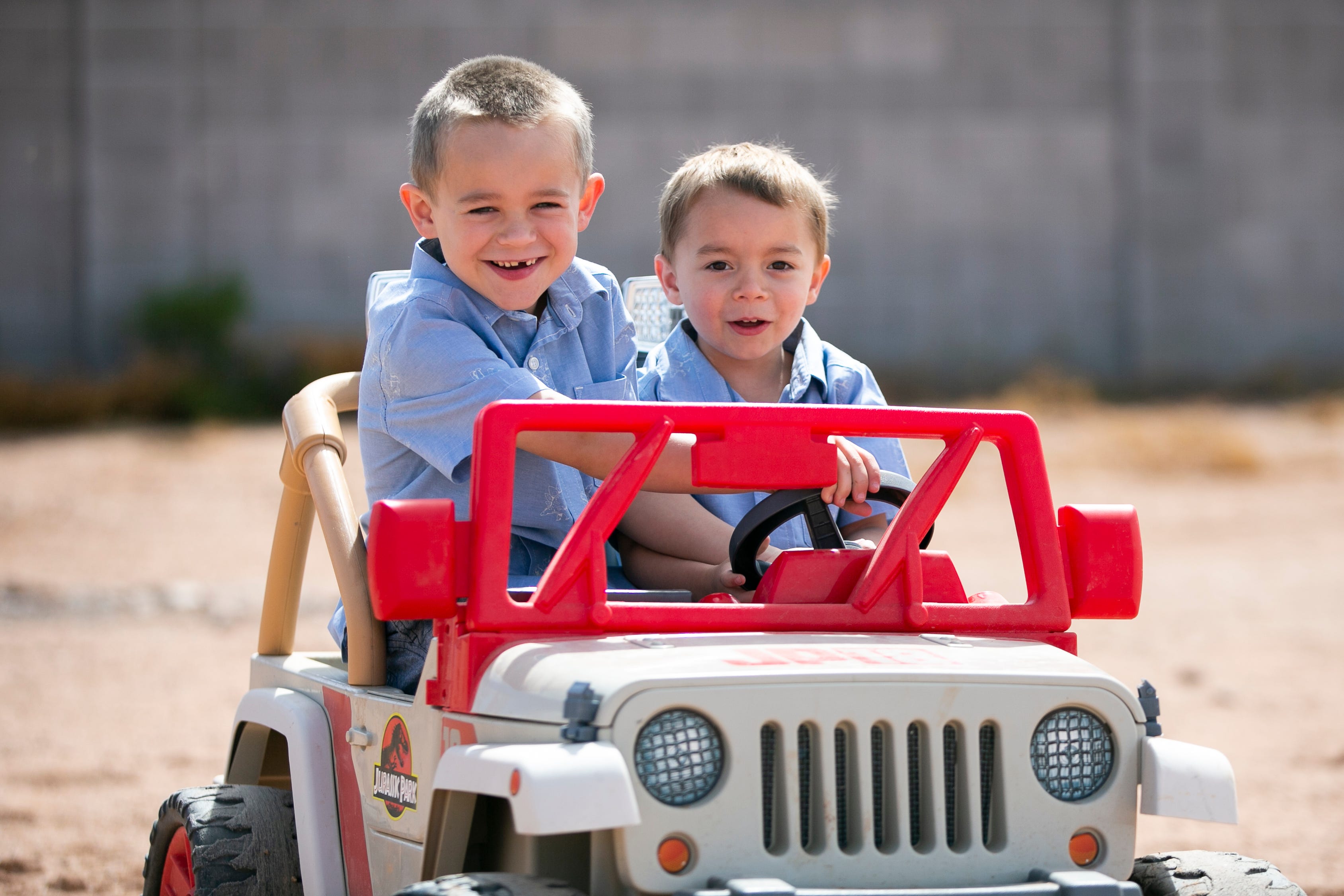 Roman Miller, 7, and his little brother Parker Miller (right), 4, drive a toy jeep in their backyard in Mesa, Ariz. on April 11, 2021.