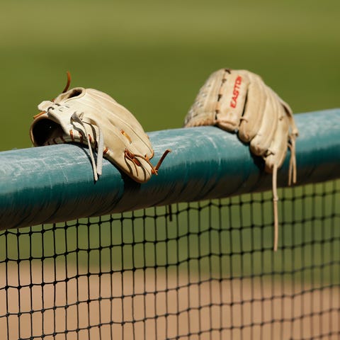 Gloves sit on the dugout wall.