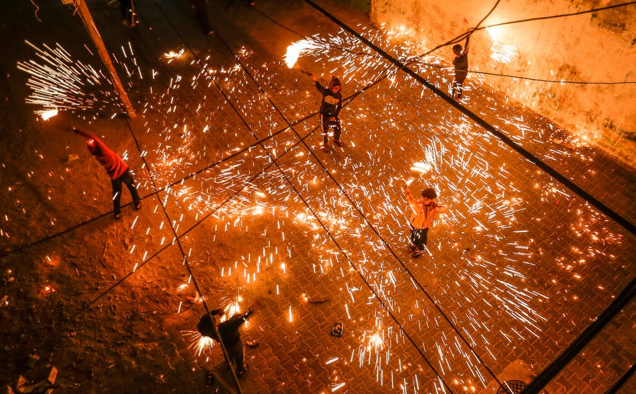 April 11, 2021: Palestinian youths swing homemade fireworks sparklers, as people celebrate on the night ahead of the Muslim holy fasting month of Ramadan, in the Rafah camp for Palestinian refugees in the southern Gaza Strip.