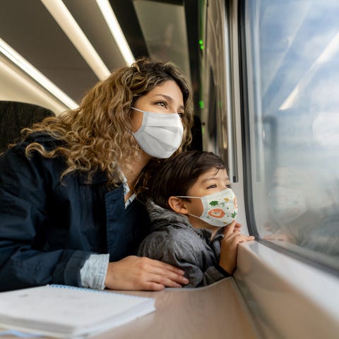 A mom and son travel by train during the coronavir
