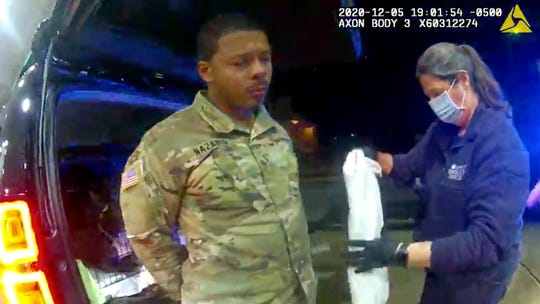 In this image made from Windsor Police video, Caron Nazario is helped by an EMT after he was sprayed with an agent by Windsor police after a traffic stop on Dec. 20, 2020, in Windsor, Va.  Nazario, a second lieutenant in the U.S. Army, is suing two Virginia police officers over a traffic stop during which he says the officers drew their guns and pointed them at him as he was dressed in uniform. Caron Nazario says his constitutional rights were violated by the traffic stop in the town of Windsor in December.
