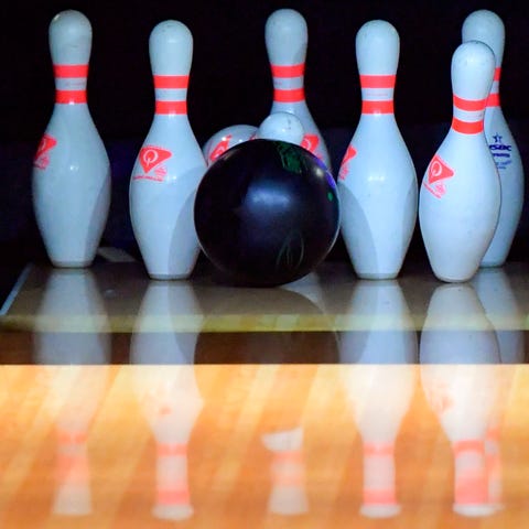 A bowling ball hits the pins.