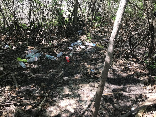 Mostly empty bottles, a pair of socks and other items litter the area where a 75-year-old man was found dead Saturday along the railroad tracks south east of 18th Street.