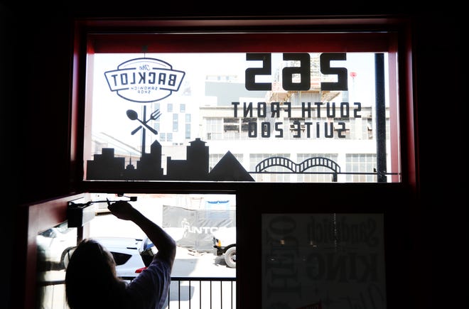 The finishing touches are applied to the entrance of Backlot Sandwich Shop off Front Street downtown Tuesday, April 13, 2021.