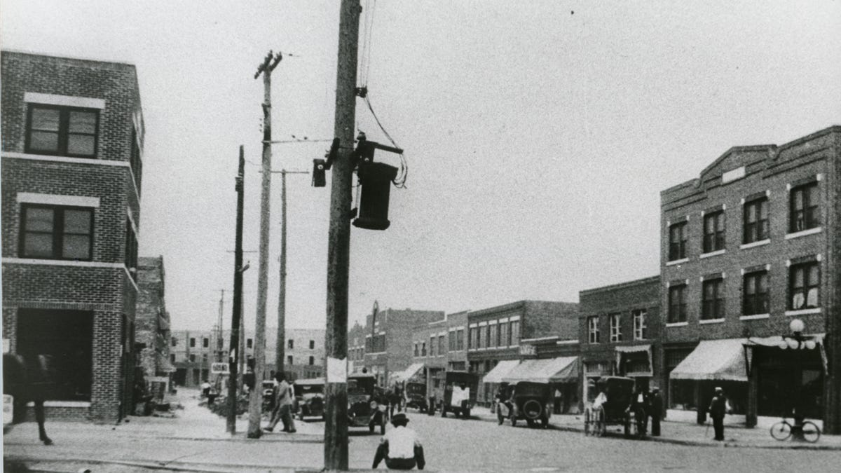 Greenwood Avenue at Archer Street in Tulsa after the reconstruction of the Greenwood District after the 1921 Tulsa Race Massacre. The three-story, brick Botkin Building is visible on the far right. It replaced a two-story brick building that stood before the massacre. The building on the far left is the reconstructed Williams Building completed in 1922.