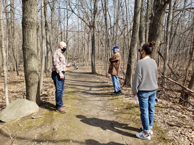 Ramsey Radakovich, left, leads Milwaukee County Board supervisors on a tour of the hiking and mountain biking trails in Mangan Woods, part of Whitnall Park, on March 30, 2021.