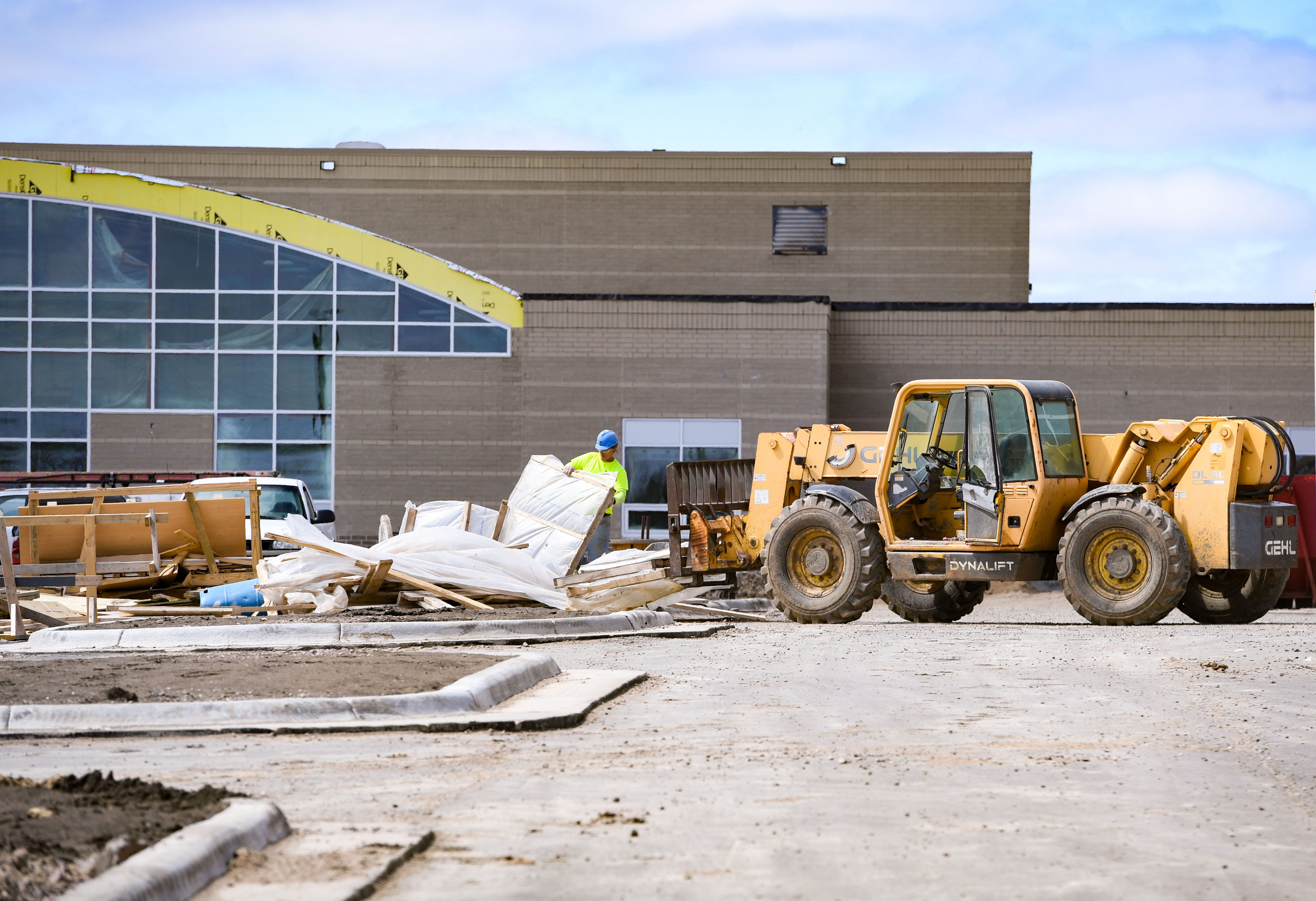 An exterior view of bulldozers in front of a school building