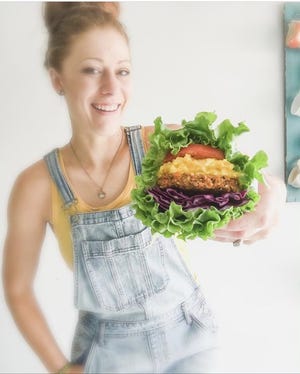 Emily Wilson poses with food she made for Bee Loved Kitchen