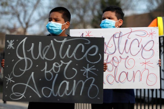 Jacob Perea, 7, left and Juan Perea, 9 holds signs on Tuesday, April 6, 2021, as they attend a press conference following the death of 13-year-old Adam Toledo, who was shot by a Chicago Police officer at about 2 a.m. on March 29 in an alley west of the 2300 block of South Sawyer Avenue near Farragut Career Academy High School.