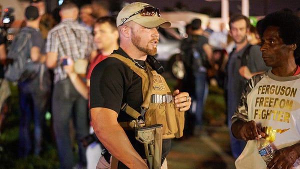 An armed member of the Oath Keepers walks through 