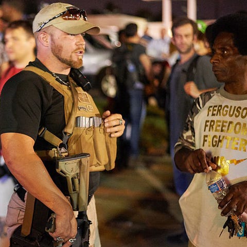 An armed member of the Oath Keepers walks through 