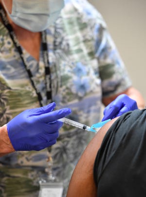 Registered Nurse Susan Bryant, infection control coordinator with Tidewell Hospice, administers the COVID-19 vaccine to a patient during a vaccination clinic held Wednesday, April 14, 2021, at Bethlehem Baptist Church on 18th Street in Sarasota.