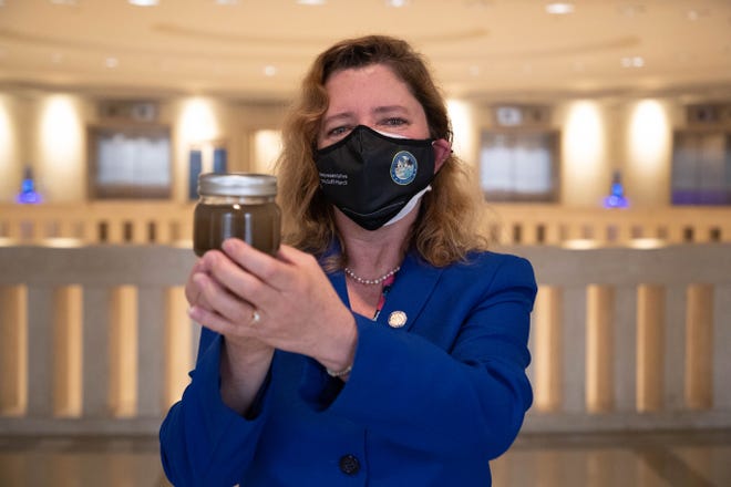 Rep. Joy Goff-Marcil holds a jar of murky water from the Indian River Lagoon which she gifted to all 120 members of the House and 40 members of the Senate to bring awareness to water quality issues and the starvation deaths of manatees in Florida Thursday, April 15, 2021. 